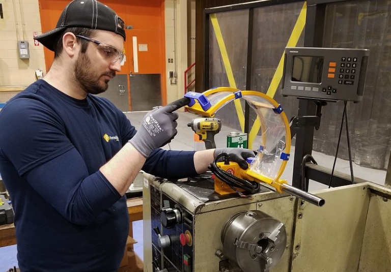 A Ferndale Safety technician installing a machine safety shield.